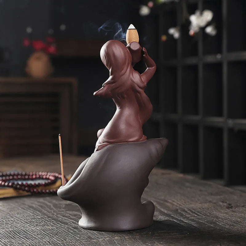 Red handmade ceramic snail-shaped backflow incense burner on a table