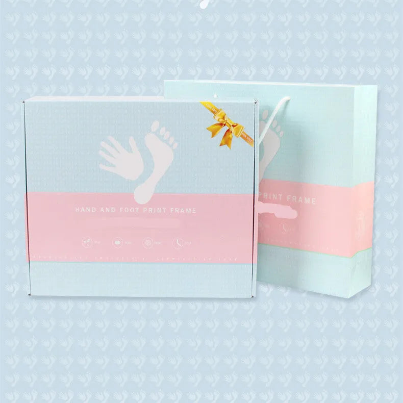 Modern DIY baby hand and foot print anniversary frame in white, shown on a shelf.