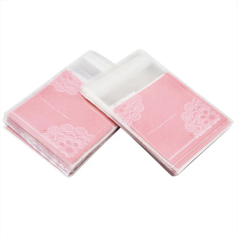 Pack of 100 small pink self-adhesive plastic bags for soap or snack packaging.