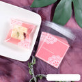 Pack of 100 small pink self-adhesive plastic bags for soap or snack packaging.