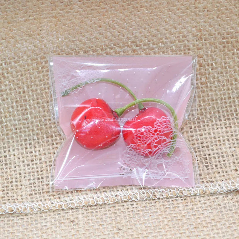 Pack of 100 small pink self-adhesive plastic bags for soap or snack packaging.