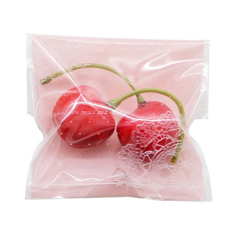 Pack of 100 small pink self-adhesive plastic bags for soap or snack packaging.