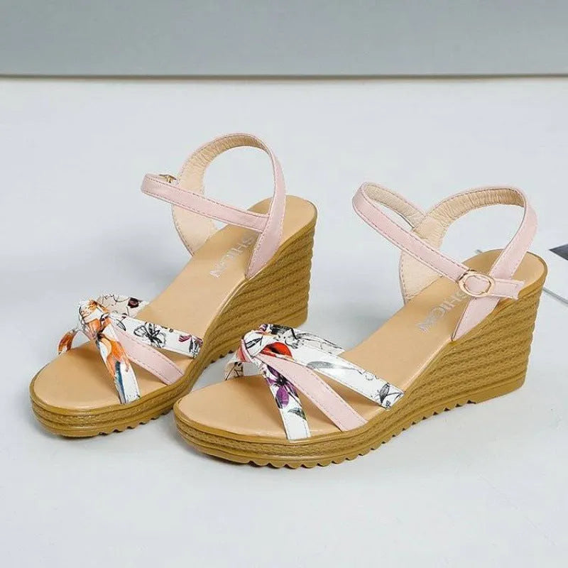 Women's pink wedge sandals with a thick heel and buckle closure on a white background.