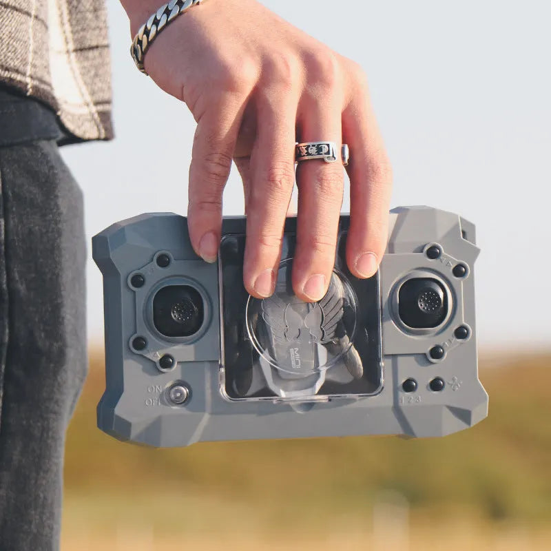 Mini folding 4K camera drone with plastic body and storage bag on a desk