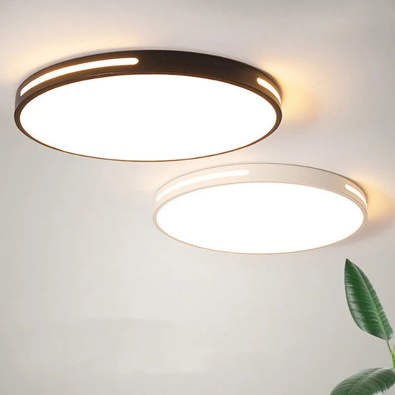 Round modern acrylic LED ceiling lamp with remote control on a white bedroom ceiling