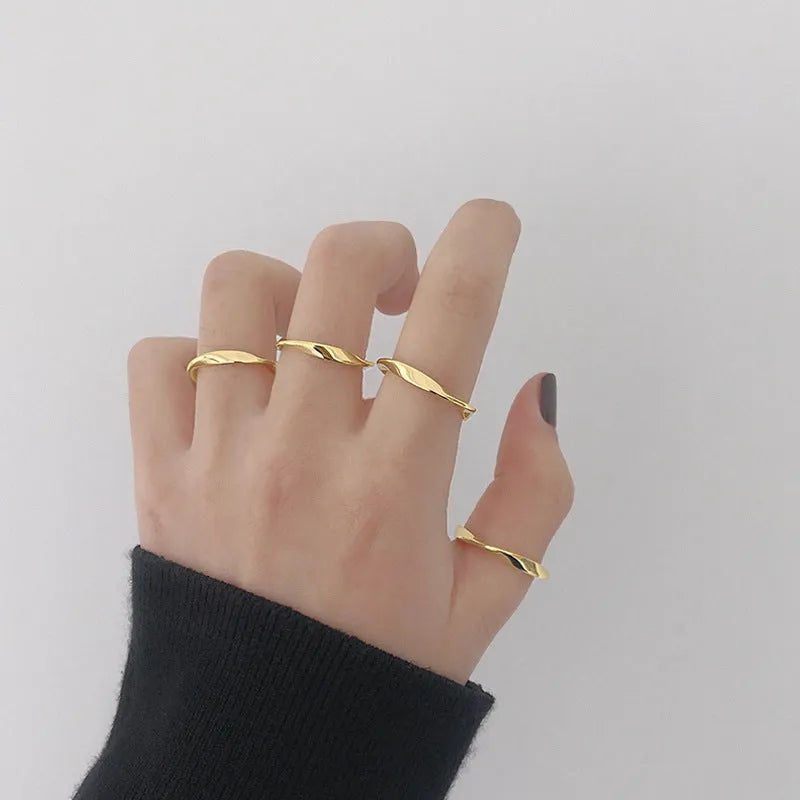 Silver Mobius twist ring with wave band design on a white background