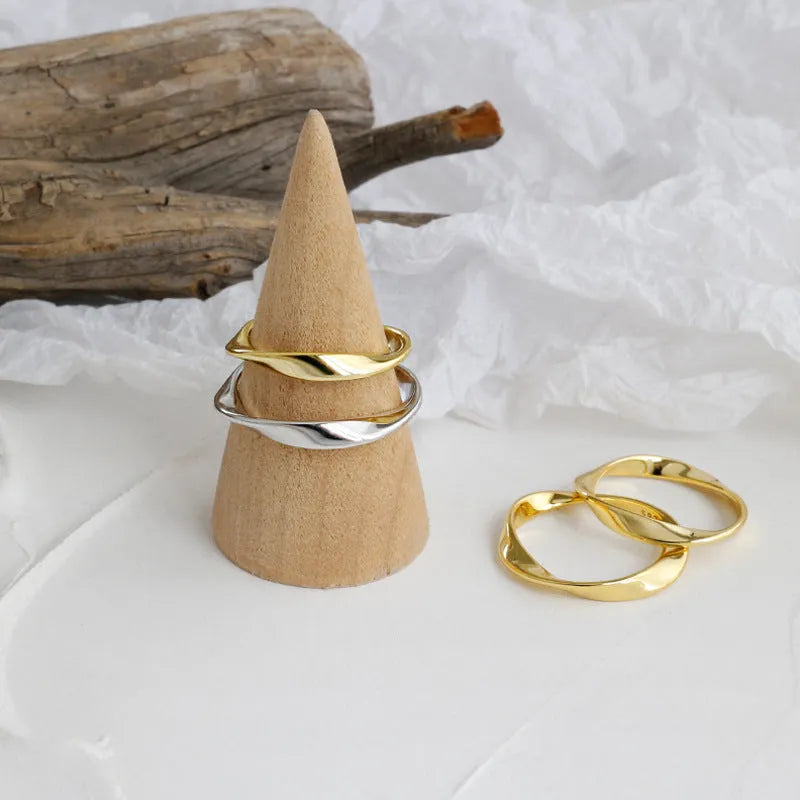 Silver Mobius twist ring with wave band design on a white background