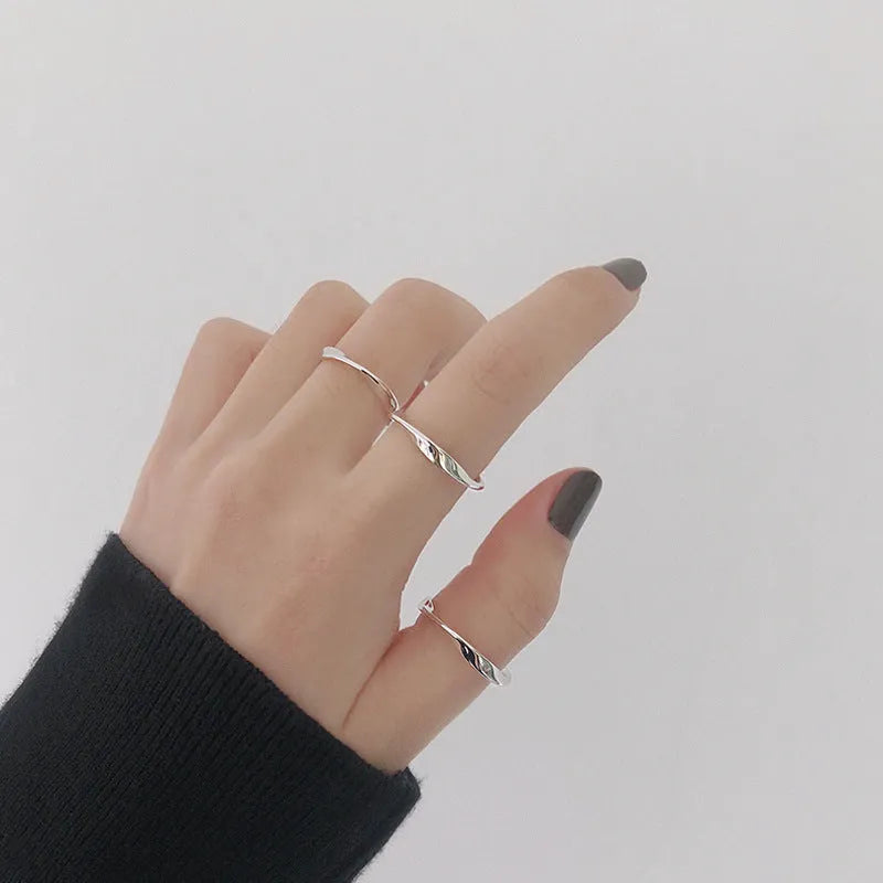 Silver Mobius twist ring with wave band design on a white background