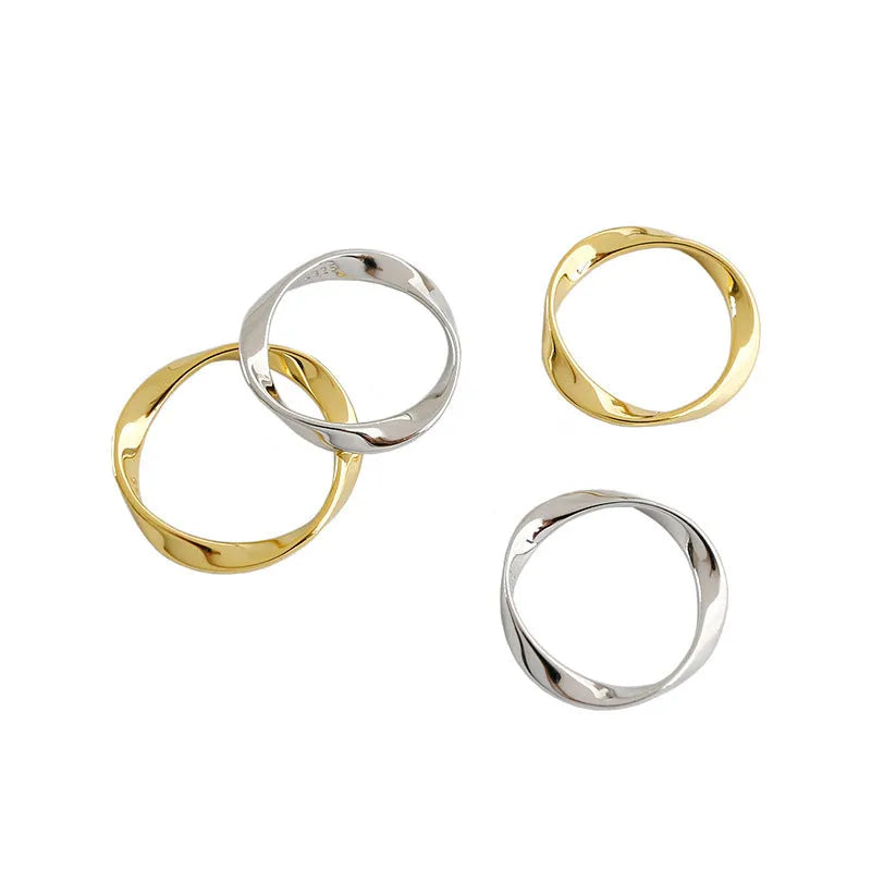 Silver Mobius twist ring with wave band design on a white background