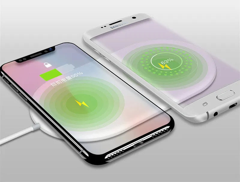 White dual wireless charger charging two mobile phones simultaneously on simple desk