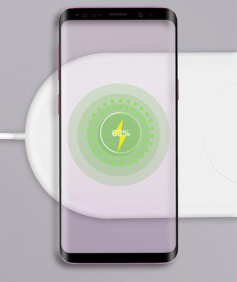 White dual wireless charger charging two mobile phones simultaneously on simple desk