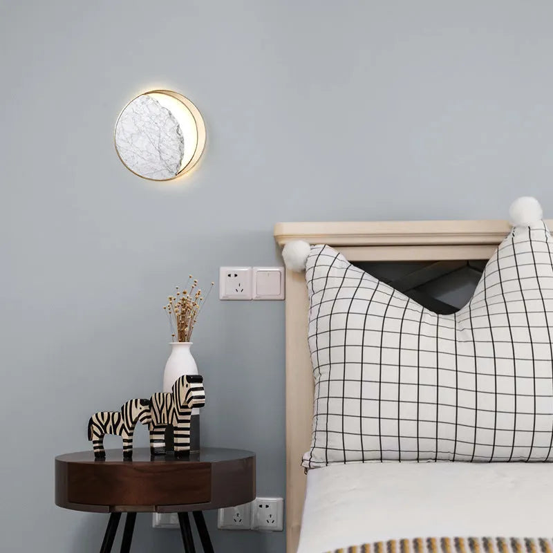 Round marble and copper Eclipse LED wall sconce with a diameter of 25cm.