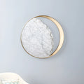 Round marble and copper Eclipse LED wall sconce with a diameter of 25cm.