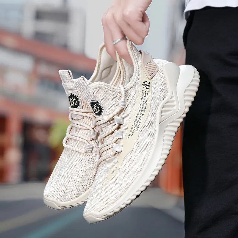 Men's white low-top sports shoes with mesh upper and rubber sole on a plain background.