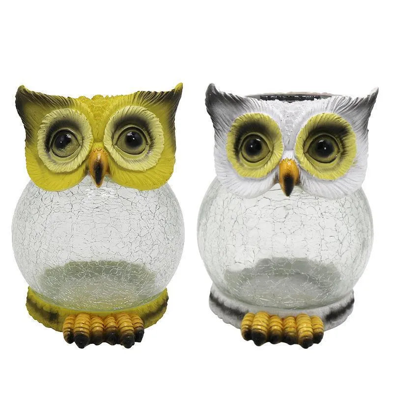 White solar-powered LED owl garden light with detailed features, placed outdoors beside plants