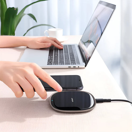 Black or white 15W wireless charging pad with zinc alloy and glass construction on a desk.
