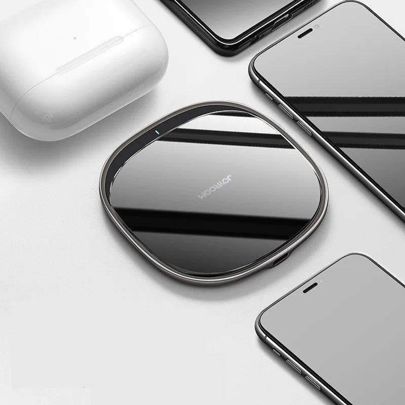 Black or white 15W wireless charging pad with zinc alloy and glass construction on a desk.