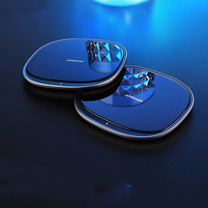 Black or white 15W wireless charging pad with zinc alloy and glass construction on a desk.