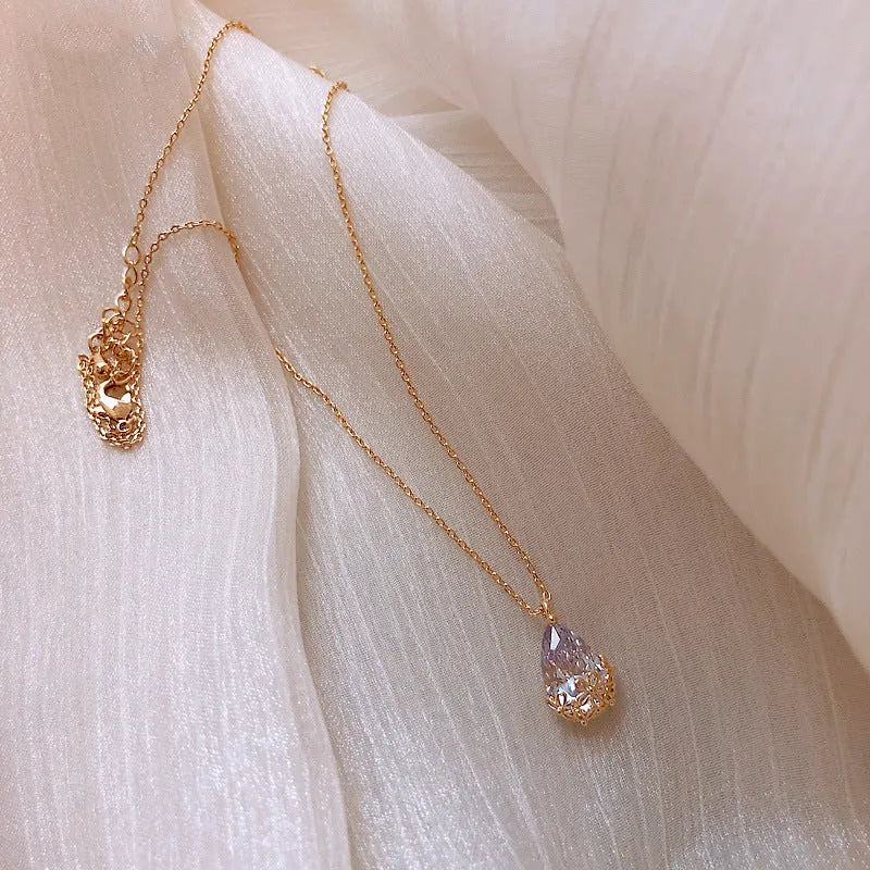 Crystal water drop pendant necklace on a woman, adjustable silver plated chain, clear drop shape pendant close up