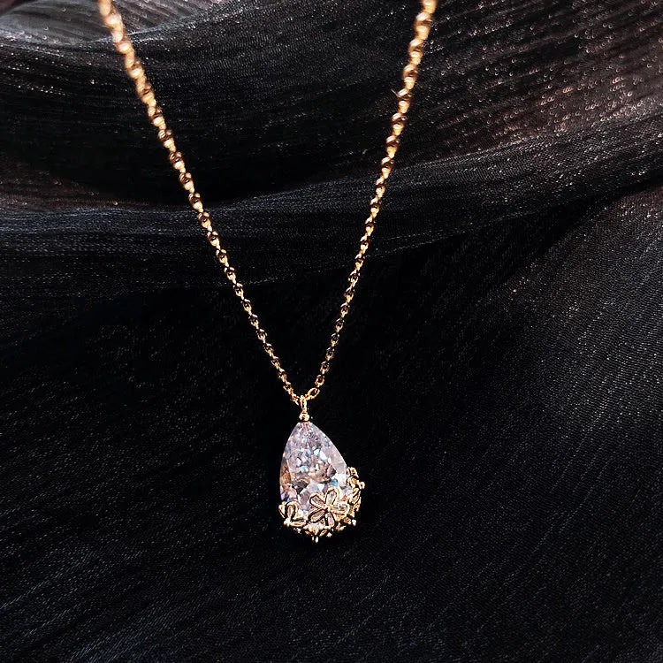 Crystal water drop pendant necklace on a woman, adjustable silver plated chain, clear drop shape pendant close up