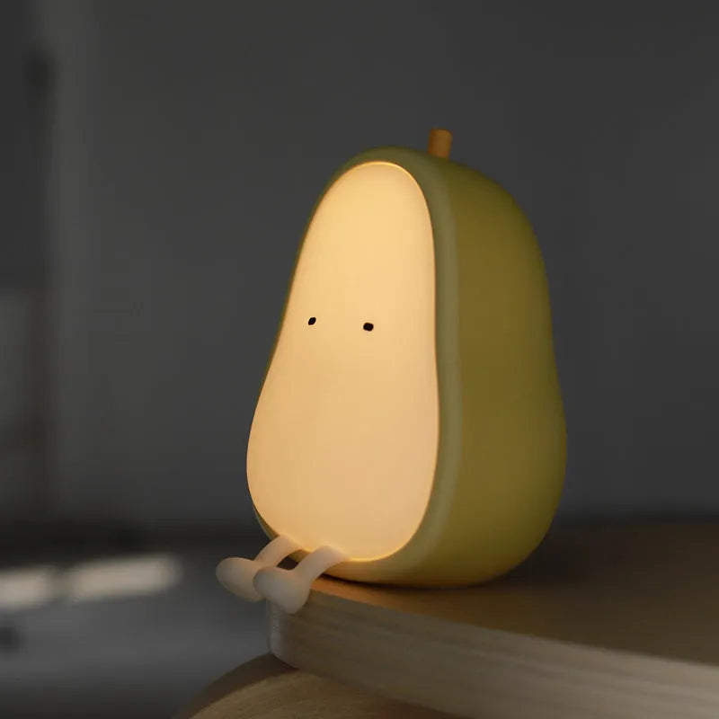 PEAR warm yellow silicone bedside night light with ABS base on a table.