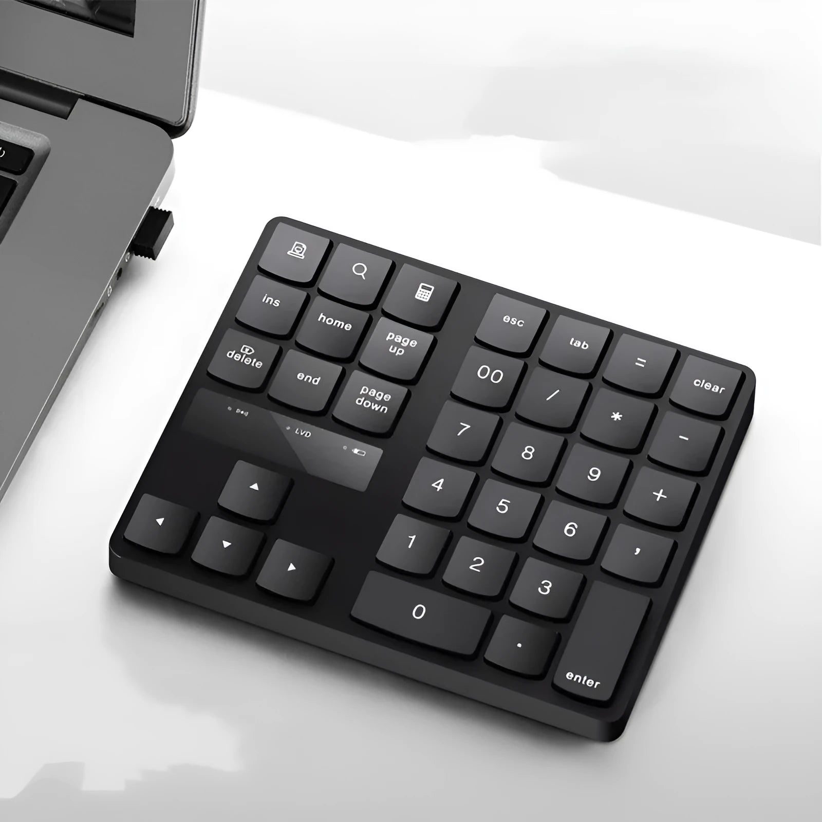 Black 35-key wireless numeric keyboard on desk with USB receiver and charging cable