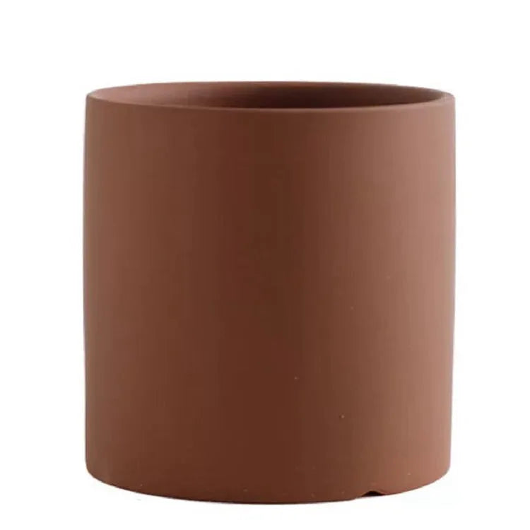 Colourful cylindrical ceramic succulent planter with drainage hole on a wooden surface