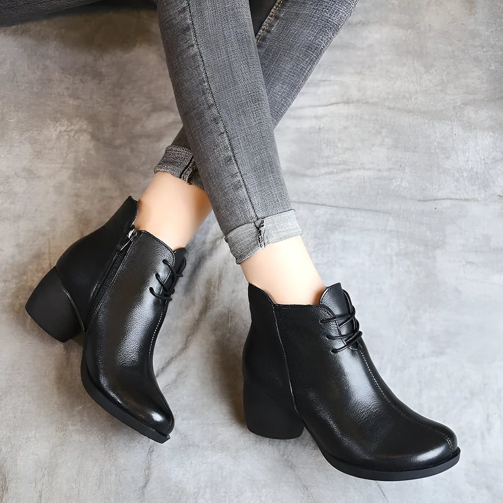 Women's black leather Martin boots with a thick mid-heel and round toe on a rubber sole.