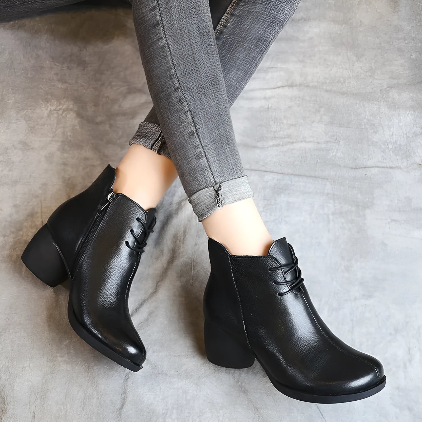 Women's black leather Martin boots with a thick mid-heel and round toe on a rubber sole.