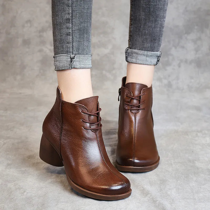 Women's black leather Martin boots with a thick mid-heel and round toe on a rubber sole.