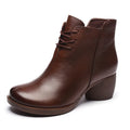 Women's black leather Martin boots with a thick mid-heel and round toe on a rubber sole.