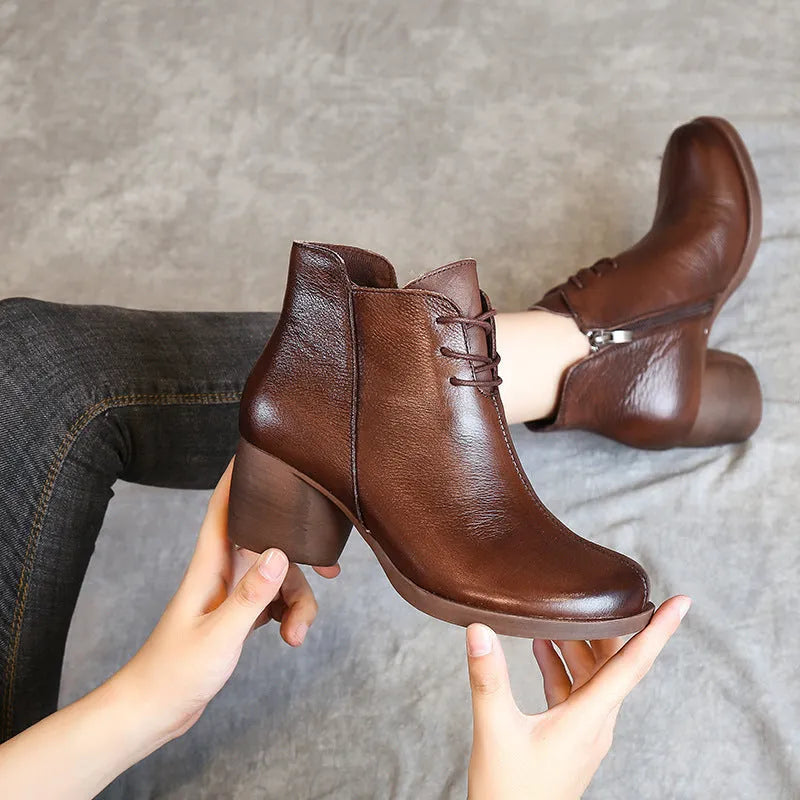 Women's black leather Martin boots with a thick mid-heel and round toe on a rubber sole.