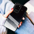 Simple black silicone phone case shown next to a navy blue version, for Samsung and iPhone models.