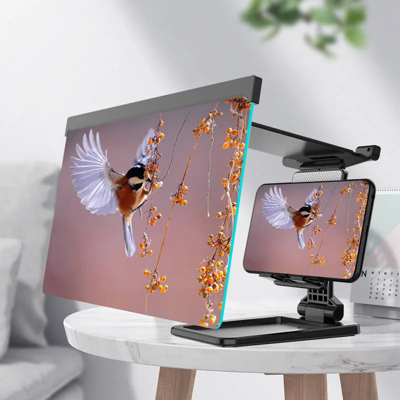Black foldable mobile phone screen amplifier with a detachable phone holder on a desktop.