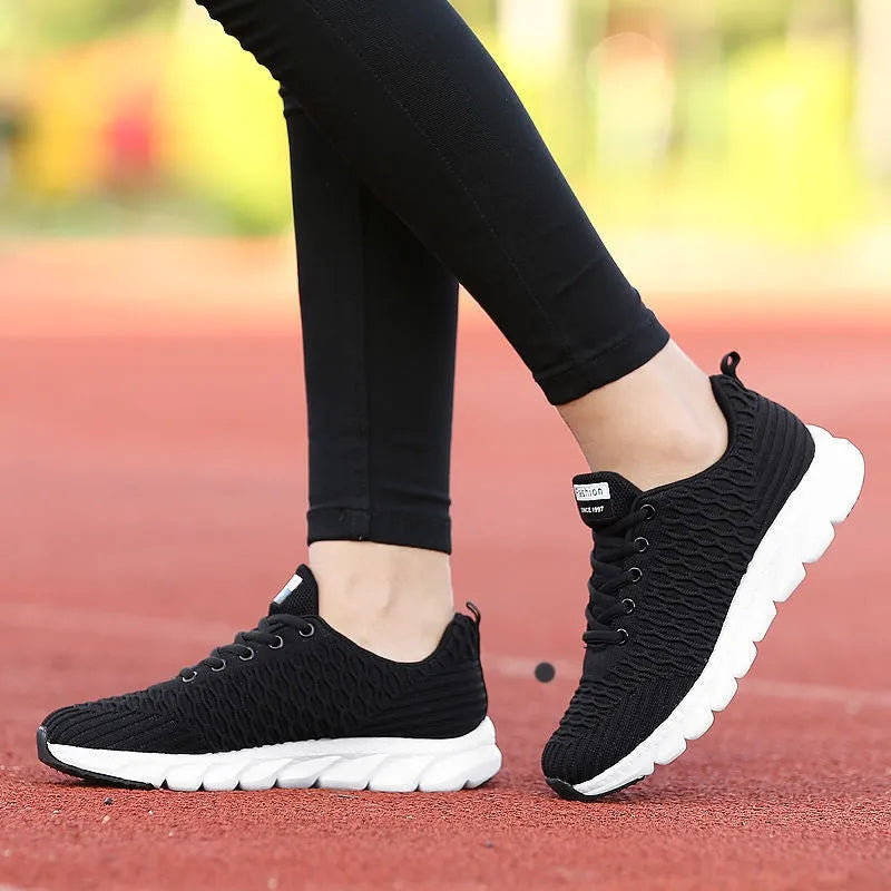 Women's running shoes with fly weave upper in black, pink or white on wear-resistant outsole.