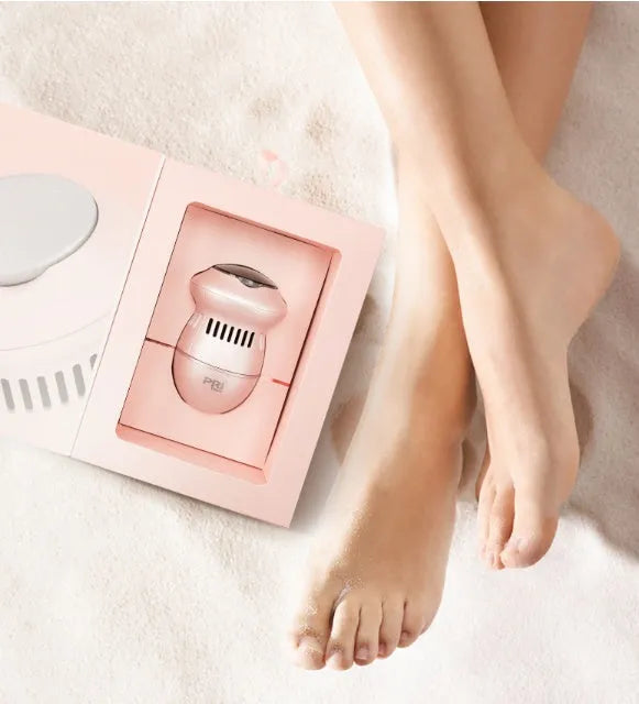 Beige and white electric foot file grinder with USB cable, two grinding heads, and cleaning brush