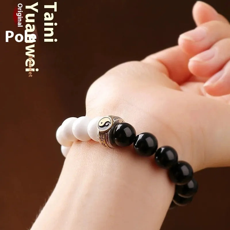 Black and white obsidian bracelet with Tai Chi symbol and mantra text on geometric beads.