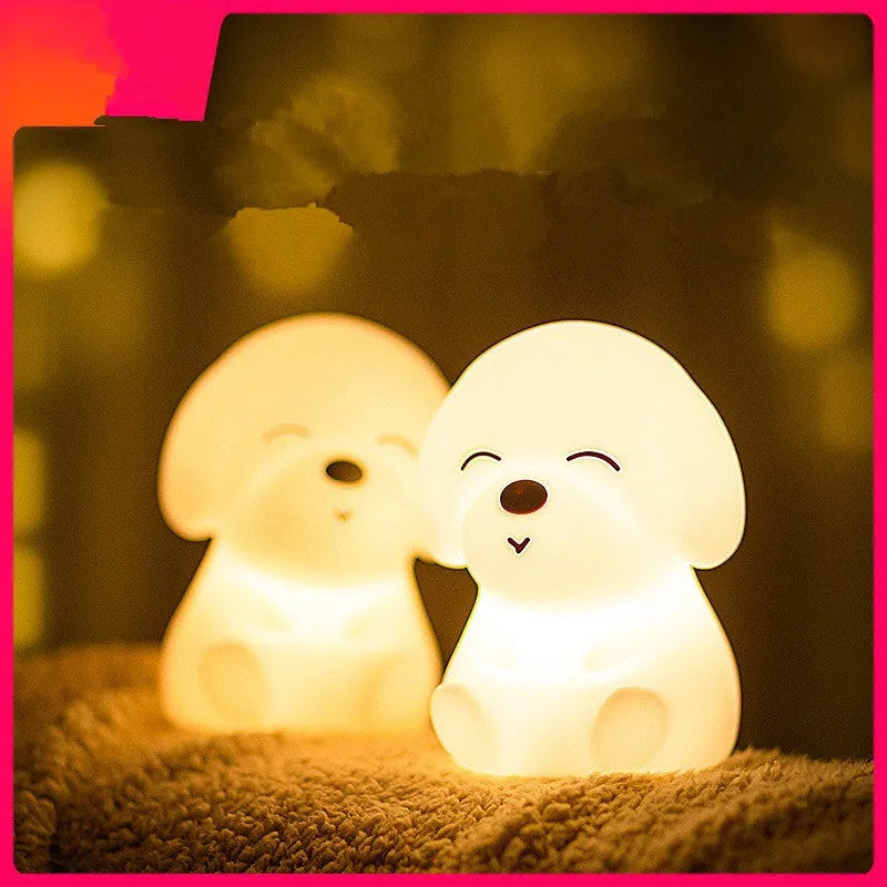 White silicone puppy-shaped LED night light with soft glow on a flat surface