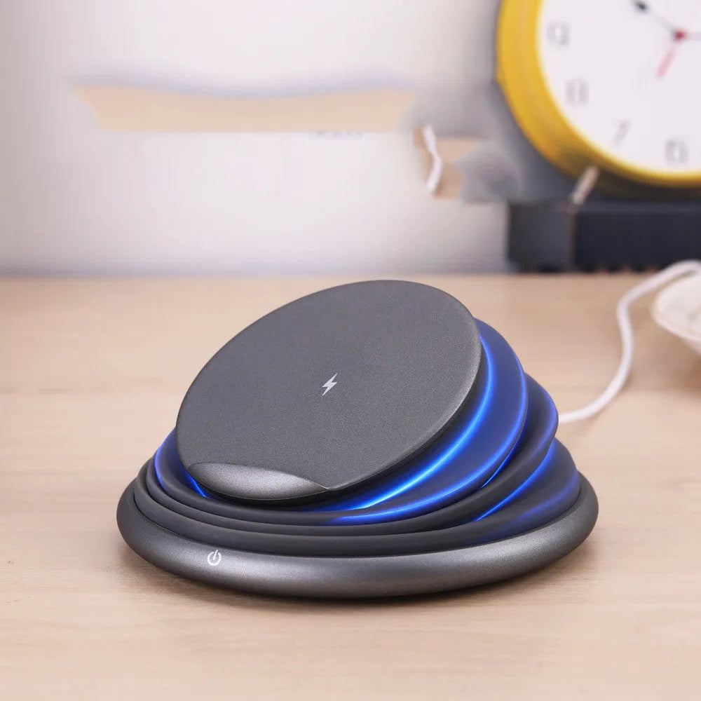 Grey wireless charging pad on a desk, 138x138x30mm, with silicone top surface and LED indicator