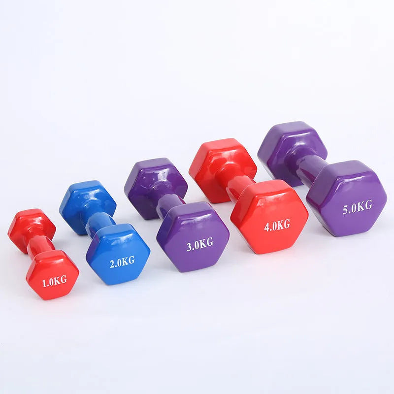A set of bright red, blue, and green plastic fitness dumbbells with glossy finish on a wooden floor.