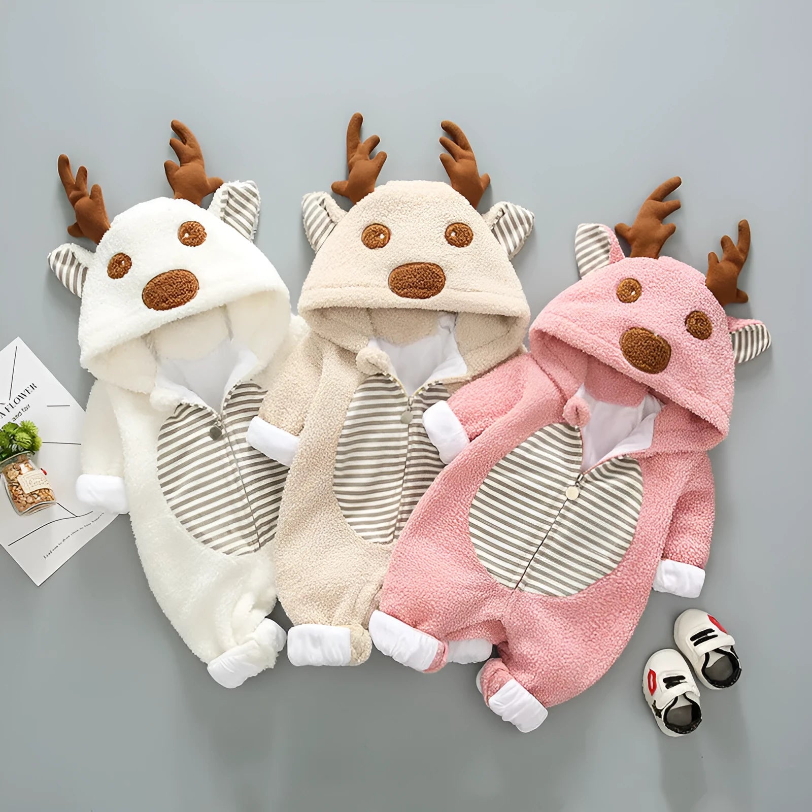 Baby wearing a long-sleeved khaki romper with lace-up strap closure on the front.
