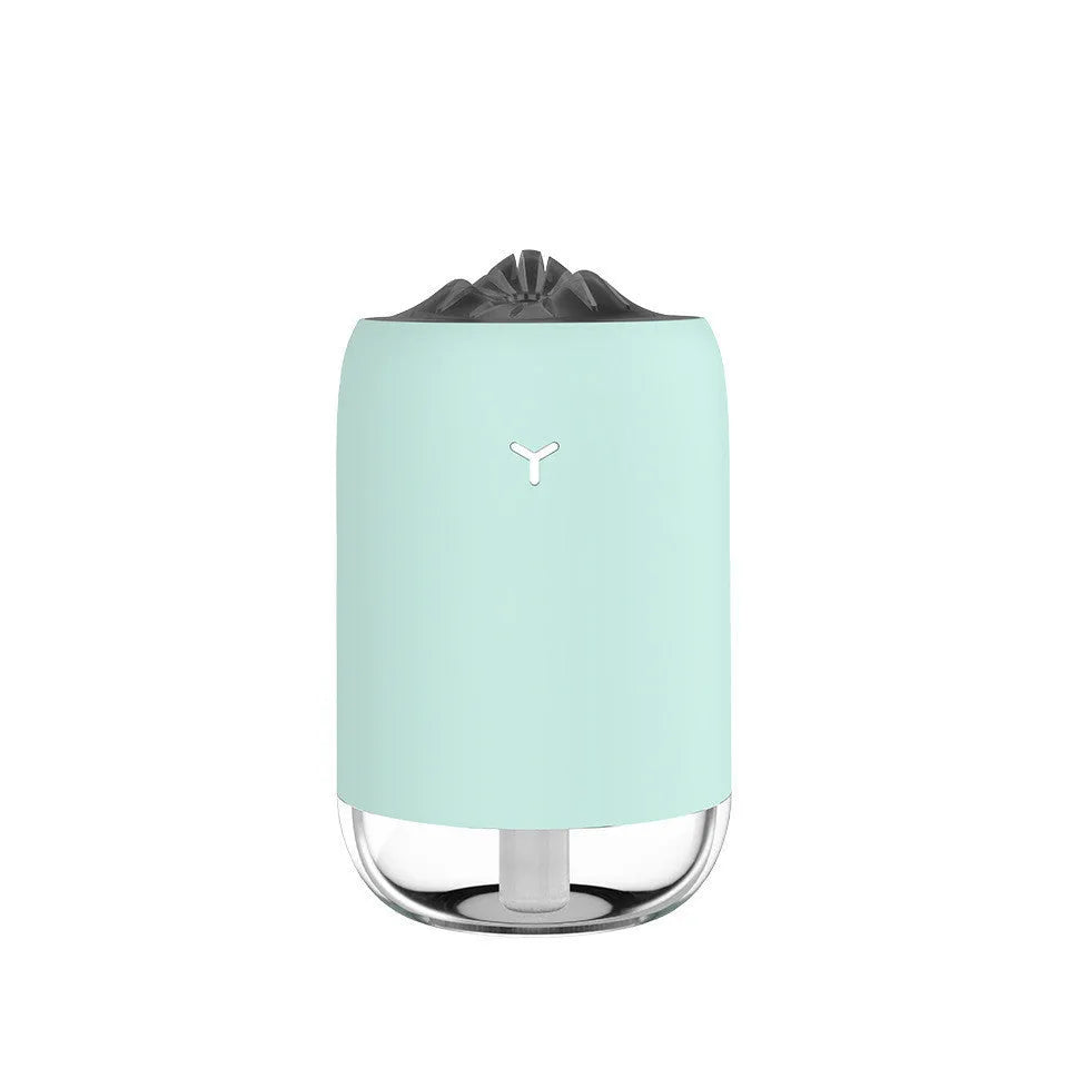 Mini cylindrical USB ultrasonic humidifier in white, pink, or green with warm night light on.