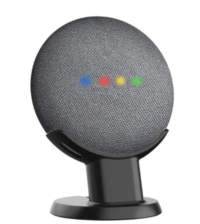 Black plastic stand holding a Google Home Mini smart speaker on a wooden table.