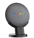 Black plastic stand holding a Google Home Mini smart speaker on a wooden table.