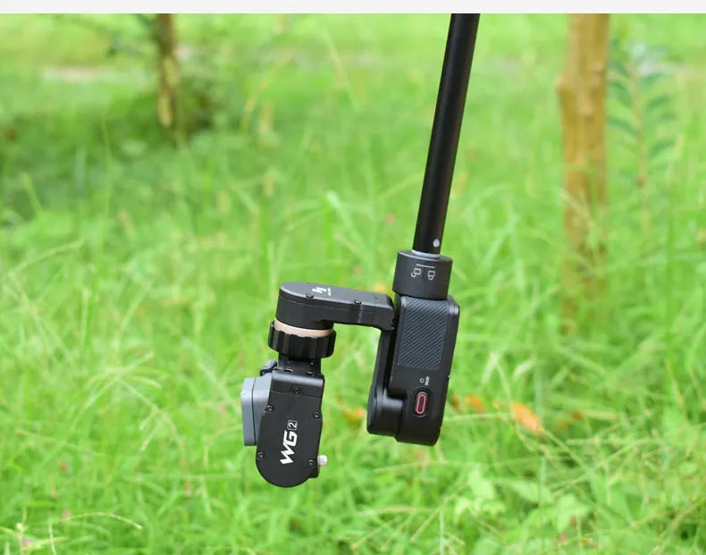Black retractable aluminium selfie stick extended to full length with a smartphone attached in the clamp.