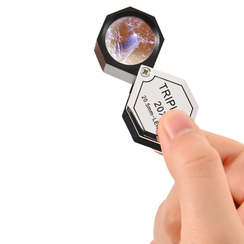 Handheld metal portable magnifying glass for jewellery and coin identification with optical glass lenses.