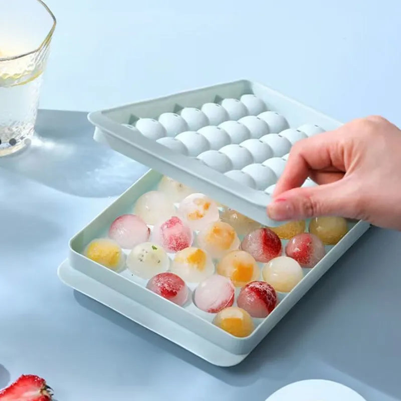 Blue silicone ice cube tray with lid showing 33 round cavities for large ice.