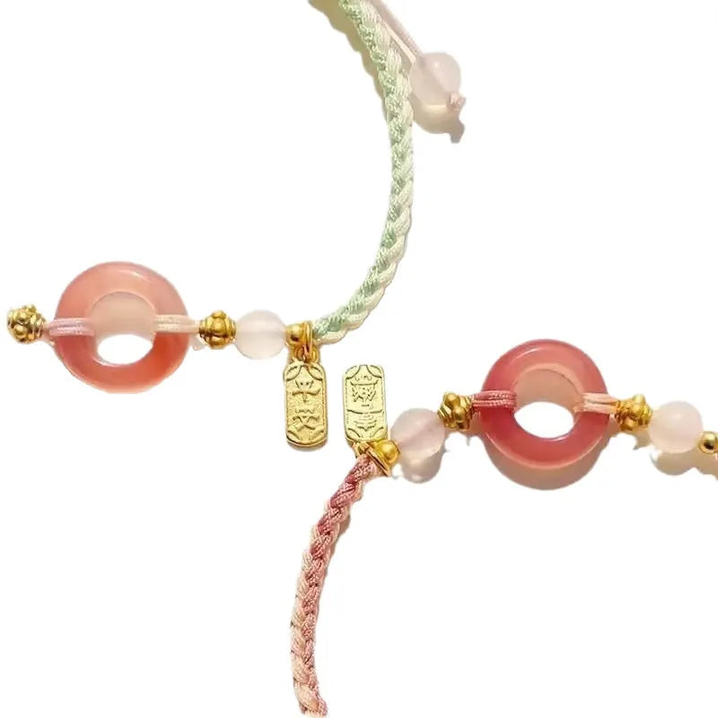 DIY woven unisex bracelet with peach blossom and peace buckle design in black, green, or pink.