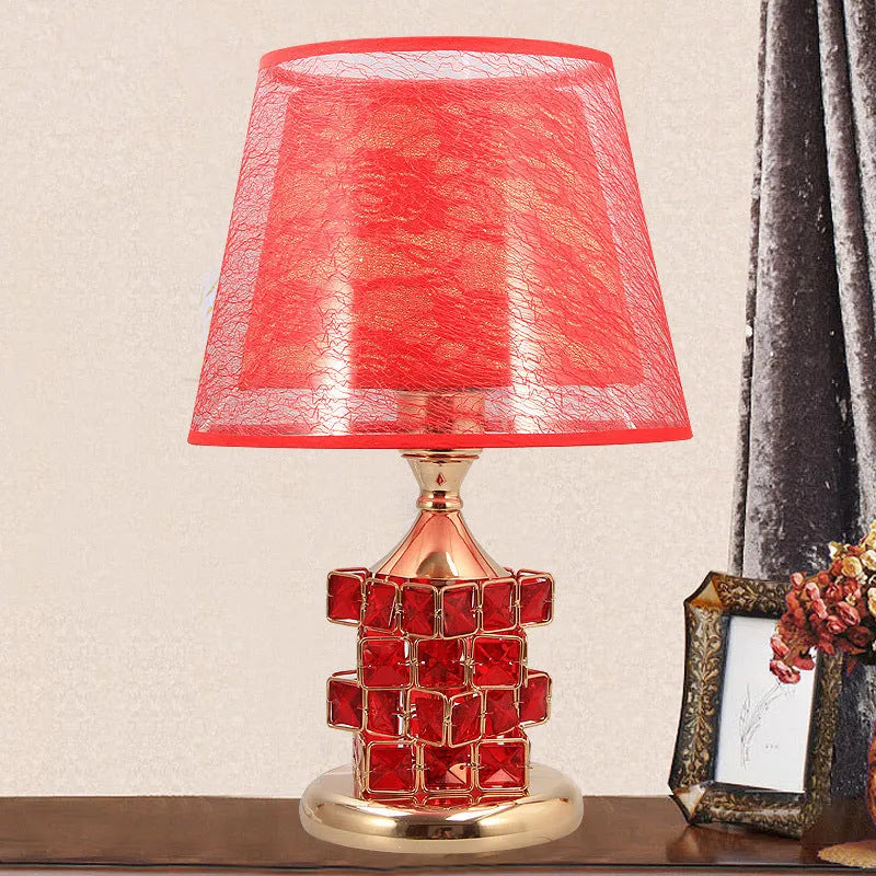 Crystal glass bedside lamp with chrome metal base, gold colour option, on a wooden bedside table