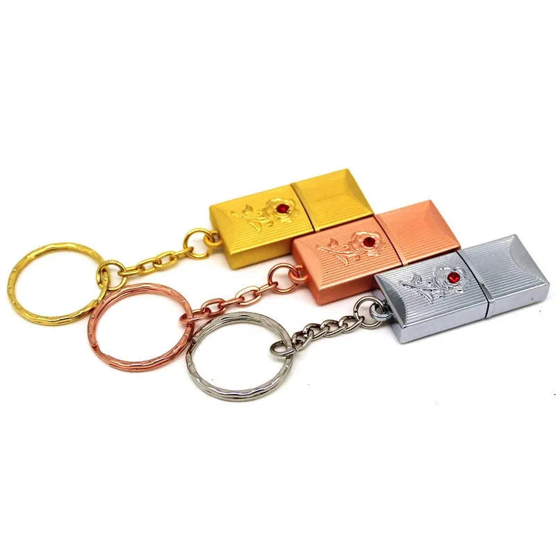 Metal and crystal USB flash drive in gold finish with decorative crystal front on white background